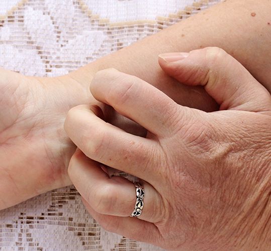 Frau kratzt sich an der Hand